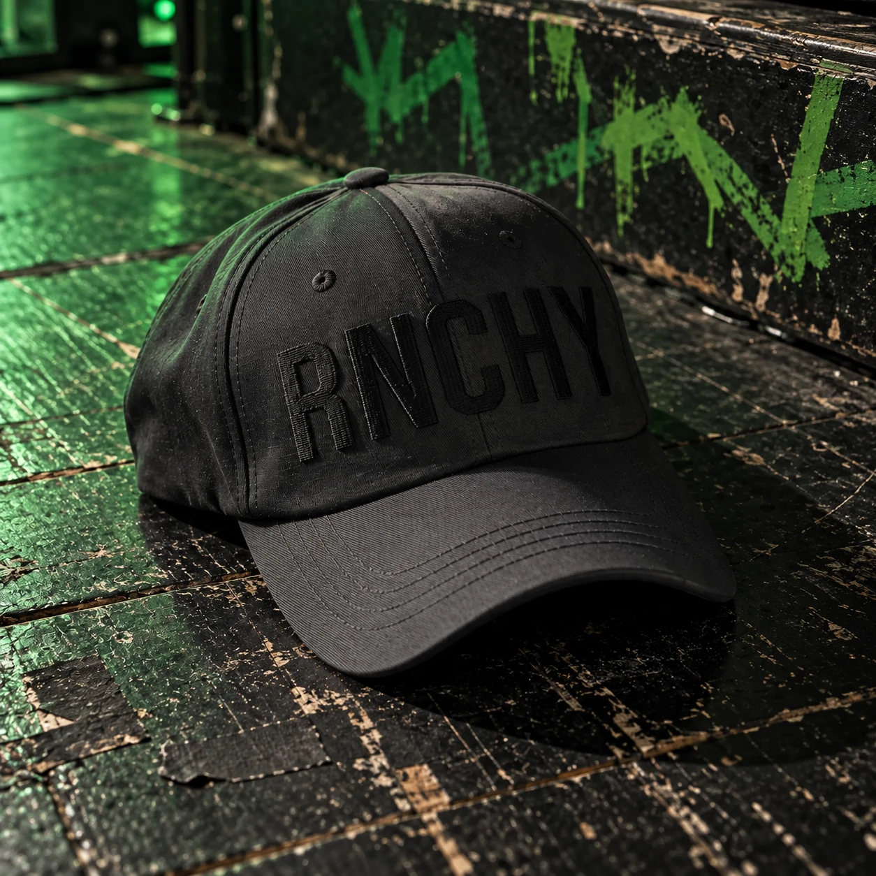 Black RNCHY cap left on a worn stage with green graffiti; product rendering